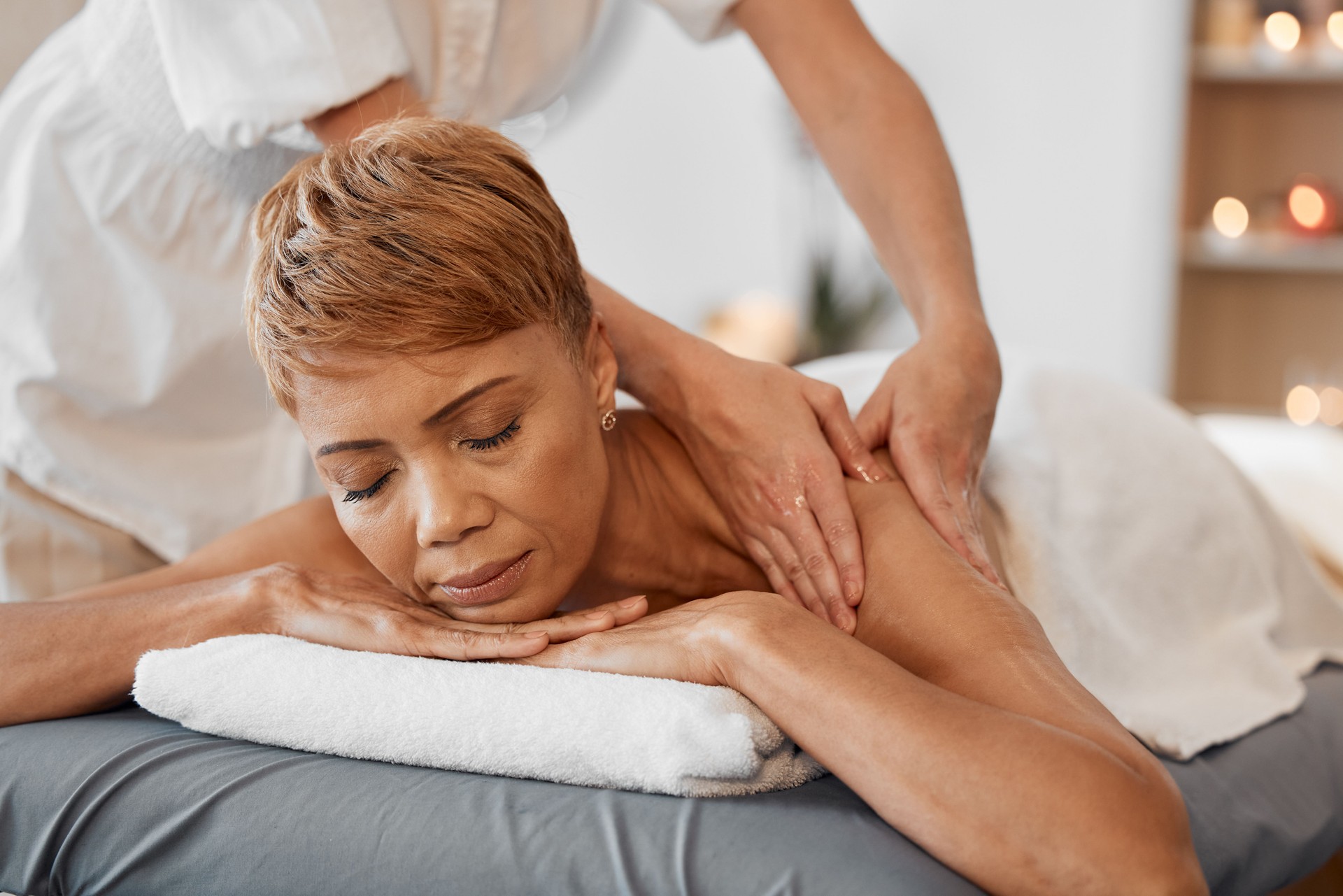 Hands, relax and black woman at a spa for a massage for back pain and body physical therapy. Relaxing, massage therapist and peaceful person resting and enjoys healthy luxury healing oil treatment